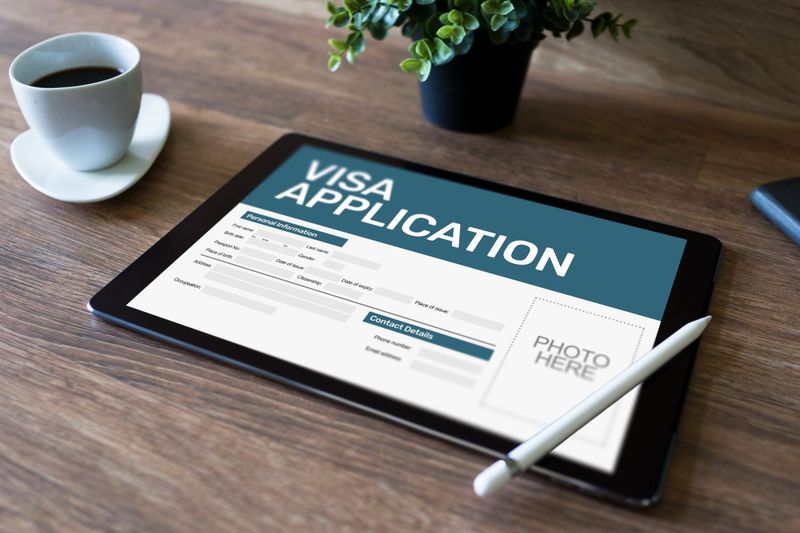 Canadian online visa application on ipad on desk next to coffee cup and plant