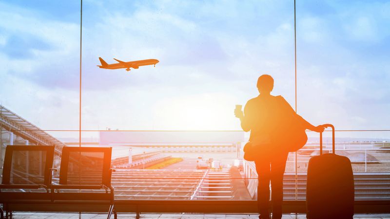 Man looking out a window at a plane