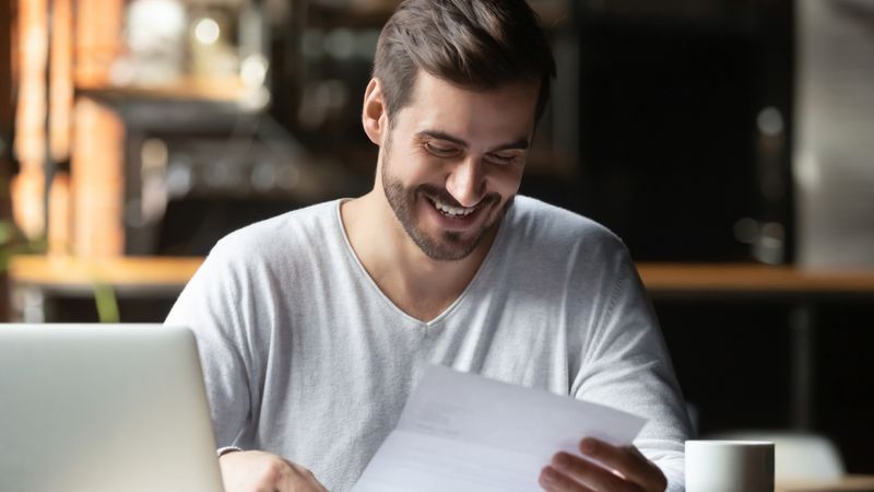 a-student-smiling-at-a-document-simon-fraser-university