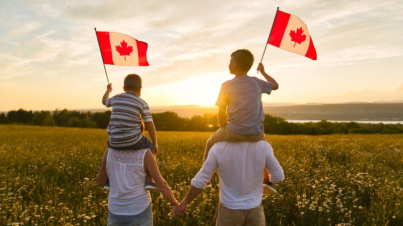 family-waving-canadian-flag-how-to-immigrate-to-canada-in-2021