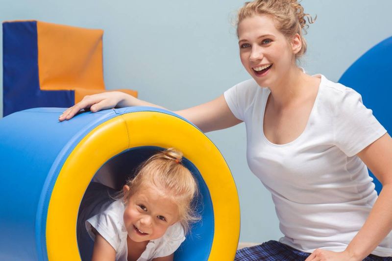 Immigrate to Canada as an Occupational Therapist young occupational therapist helping child exercise | move to Canada